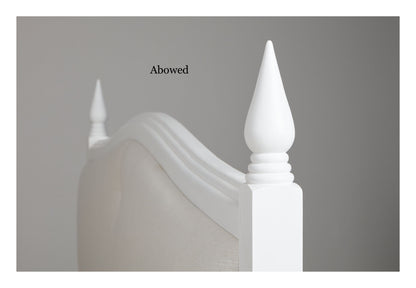 Elegant white french style bed, candle shaped hand turned finials and off white linen headboard with button , curved headboard moulding match the bed posts turnings.
