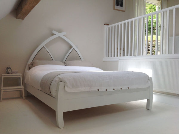 Modern white wooden bed with upholstered arched headboard