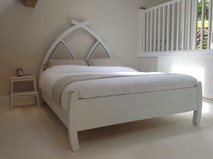 Handmade wooden bed with linen headboard