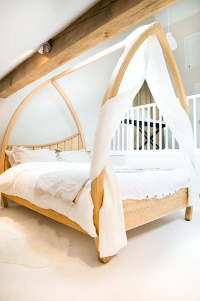 Pine four poster bed with curved posts. 